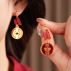 Detail of vintage style enamel gold earrings with red Chinese lucky charms
