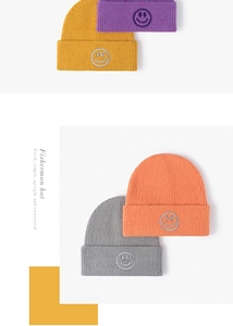 Detailed view of colorful knitted beanies with smiley face embroidery patches