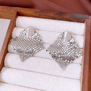 Detailed macro view of silver mesh tassels and polished geometric rhodium plated earrings