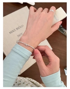 Dettaglio del bracciale con fiocco in argento s925 e anello coordinato su modella elegante