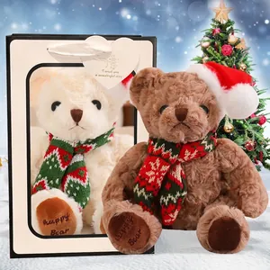 Plush Christmas teddy bear with red hat and scarf in a white gift bag with heart tag