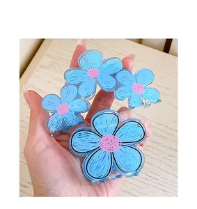 Detailed view of floral acrylic hair claw clips in pastel blue and pink tones