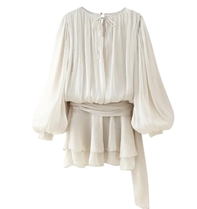 Détail d'une robe courte en mousseline blanche avec manches lanternes et ceinture