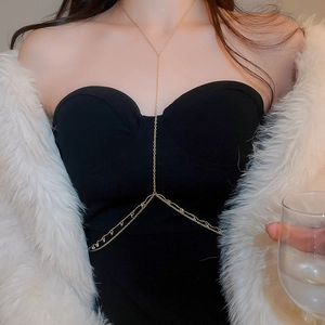 Close-up of a gold body chain with shimmering zircon beads on a fashion model