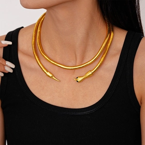 Detail of gold snake-shaped necklace with intricate scale texture and black-eyed serpent head
