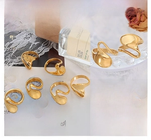 Macro view of gold fluid geometric rings set featuring polished metallic texture and shine