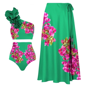 Détail à plat du maillot une épaule vert émeraude avec imprimé floral rose et paréo