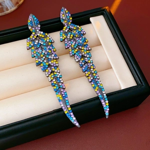 Boucles d'oreilles plume vintage avec strass multicolores dans un écrin à bijoux