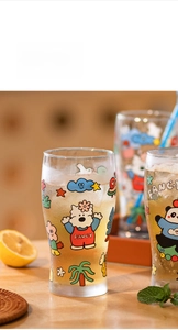 Close-up of glass beer mug with cute bear prints, ice cubes and fresh condensation