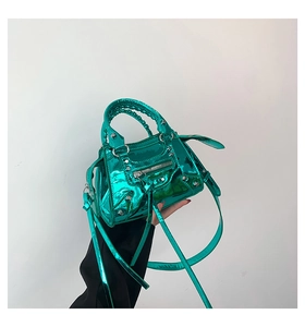 Detailed shot of bright green patent leather bag with iconic silver rivets and long tassels