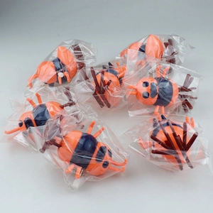 Detail of wind-up ant toys in individual plastic packaging with white knobs