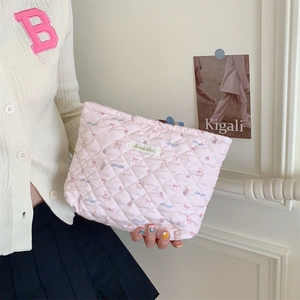 Detailed texture of quilted fabric makeup bag with cute bear and bow patterns