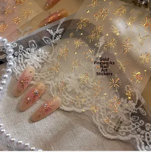 Detailed view of 3D metallic fireworks and star patterns on gold nail art stickers