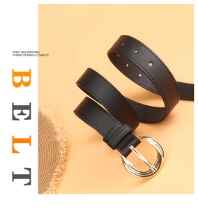 Close-up of black faux leather belt with double gold rings and fine stitching on a warm background