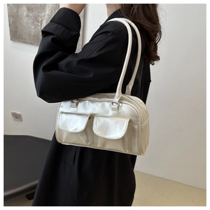 Detail of silver metallic rectangular handbag with dual front pockets and thin straps