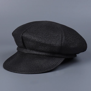 Detail of black woven straw baker boy hat showing intricate texture and stiff brim