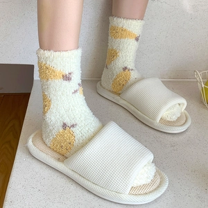Détail de chaussettes en molleton corail à fruits et pantoufles gaufrées blanches