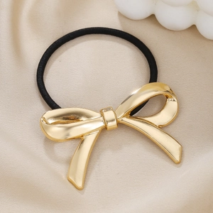 Chic gold metallic bow hair tie with high elastic black band on a satin background