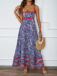 Detail of summer slip dress featuring blue floral print and red wavy trim accents
