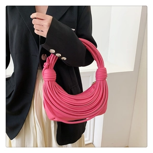 Detailed view of pink woven leather shoulder bag with decorative large knot handle detail