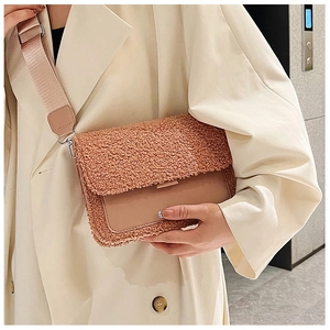 Detail of small crossbody bag featuring lamb wool patchwork and wide woven strap