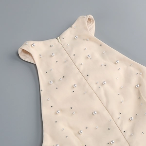 Close-up of cream dress with white pearls, silver rhinestones and invisible back zipper