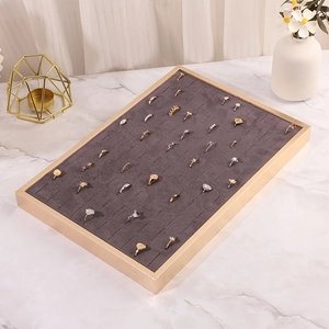 Macro shot of grey velvet slots in golden metal jewelry tray for ring display