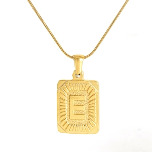 Macro shot of 18K gold plated rectangular pendant featuring engraved capital letter E