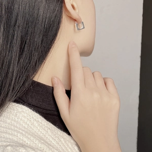 Minimalist square open hoop earrings in 925 sterling silver worn by a model