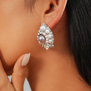 Close-up of vintage flower earrings with grey and white pearls and crystal pavé on model