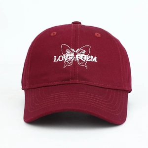 Detail of burgundy baseball cap with white butterfly embroidery and LOVE POEM text.