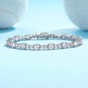 Elegant S925 sterling silver tennis bracelet with round cut moissanite stones on light blue background