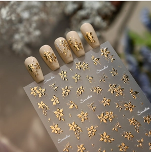 Macro shot of gold floral nail stickers with elegant metallic leaf patterns and sunshine text