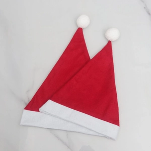 Classic red Christmas hats set of two with white plush trim on marble background
