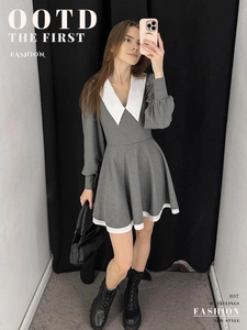 Detail of grey puff sleeve dress featuring a white pointed collar and patchwork hem design