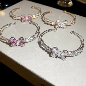 Double-layered butterfly open bangles with shimmering zircons in gold and silver finish
