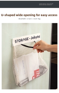 Detail of hand opening an elastic wall-mounted mesh storage bag for grocery bags