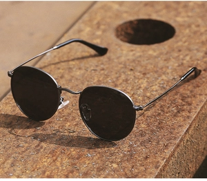 Close-up of vintage round polarized sunglasses with industrial textured metal frames