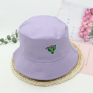 Close-up of cactus embroidery on a light purple cotton bucket hat with cactus text detail