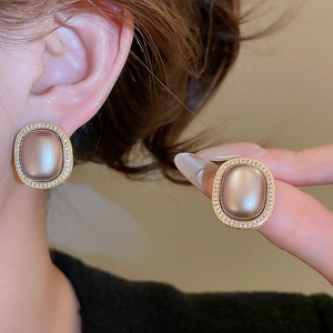 Detail of oval champagne zircon earrings with micro-pave diamonds and vintage gold plating