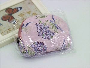 Detail of pink floral fabric coin purse with blue lavender patterns in clear packaging