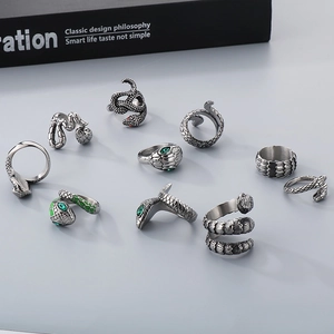 Detailed collection of vintage silver snake rings with red and green gemstone eyes
