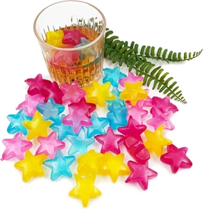 Close-up of star-shaped colorful reusable plastic ice cubes in a glass of amber liquid