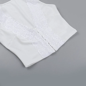 Dettaglio del bordo in pizzo bianco sullo scollo a V profondo del crop top corto