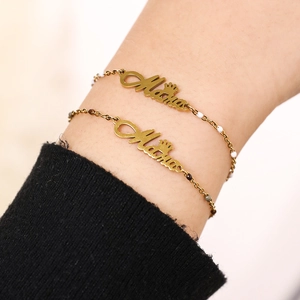 Close-up of golden Mama letter bracelet with small crown and colorful beads on wrist
