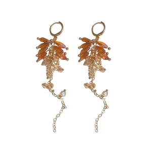 Bohemian crystal droplet fringe earrings with amber beads and gold tassel on white background