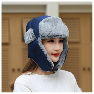 Close-up of navy blue winter trapper hat with thick gray faux fur lining and ear flaps