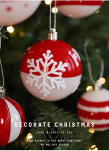 Gros plan de boules de Noël rouges et blanches avec motifs flocons sur fond festif chaleureux
