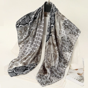 Détail d'une écharpe en imitation soie à imprimé cachemire gris sur un cintre blanc