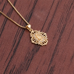 Collier doré avec pendentif icône religieuse pavé de zircons sur fond en bois